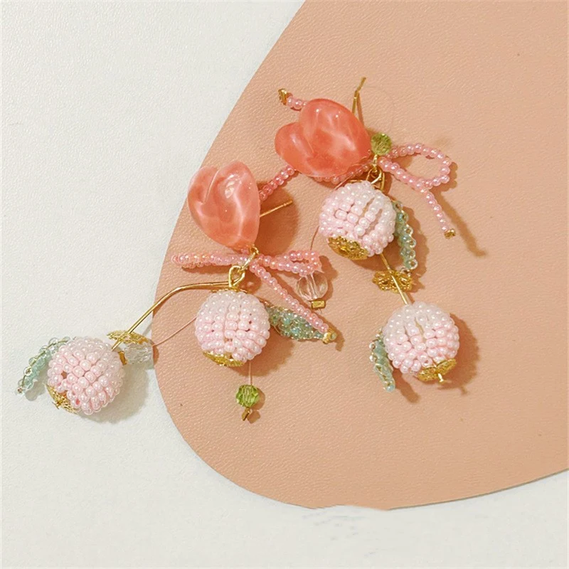 Title 6, Peach roze strik oorbellen voor dames. Een scha...