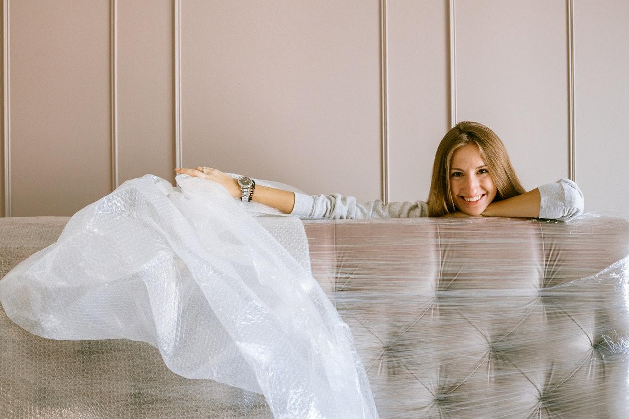 A smiling woman holding bubble wrap