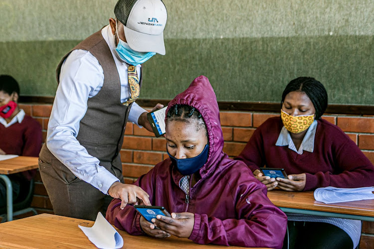 Kamogelo Mashotja, from the Odin Ed tech support team, helps a grade 11 pupil navigate her new Omang ed-tech tablet at Nqweba Secondary School in Graaff-Reinet.