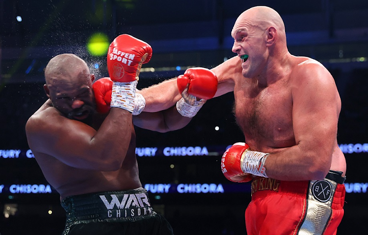 Derek Chisora (left) and Tyson Fury exchange punches during their WBC heavyweight championship fight at Tottenham Hotspur Stadium in London on December 3 2022.