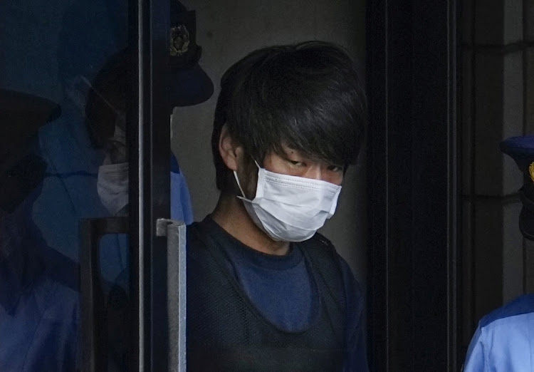 Tetsuya Yamagami, a suspected of killing former Japanese premier Shinzo Abe, is escorted by a police officer as he is taken to prosecutors, at Nara-nishi police station in Nara, western Japan, in this photo taken by Kyodo July 10, 2022. Mandatory credit Picture: KYODO via REUTERS