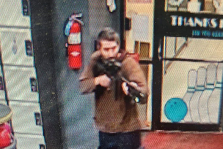 A man identified as Robert R Card by police points what appears to be a semiautomatic rifle in Lewiston, Maine in the US on October 25 2023.