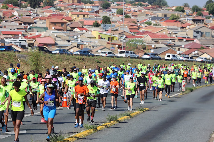 Runners in the 21km and 10km events merge at the Soweto Highway to FNB Stadium during the Soweto Marathon on November 6 2022.