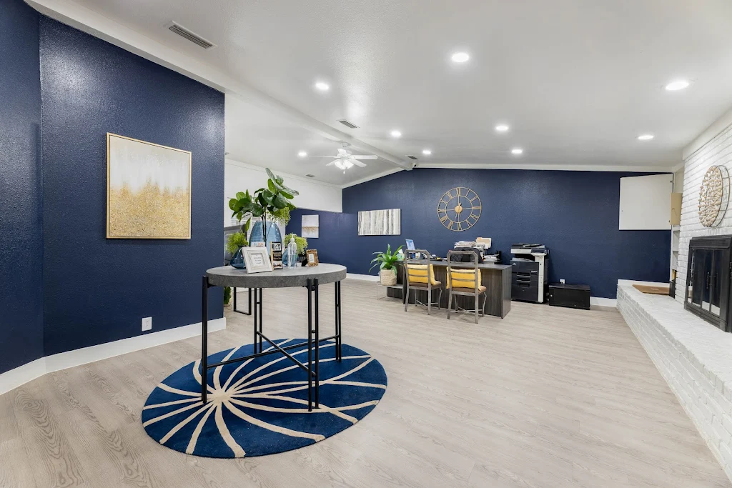 Leasing office with dark blue painted walls, a vaulted ceiling with can lighting, and modern decor