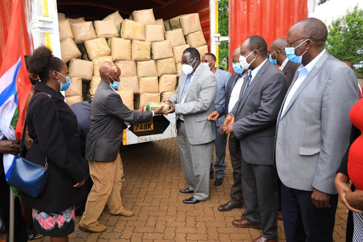 A farmer receives a packet of seeds from Governor James Nyoro on Wednesday.