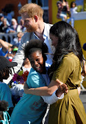 An enthusiastic royal fan shares a hug with Meghan, Duchess of Sussex, on September 23 2019 in the Bo-Kaap, Cape Town.