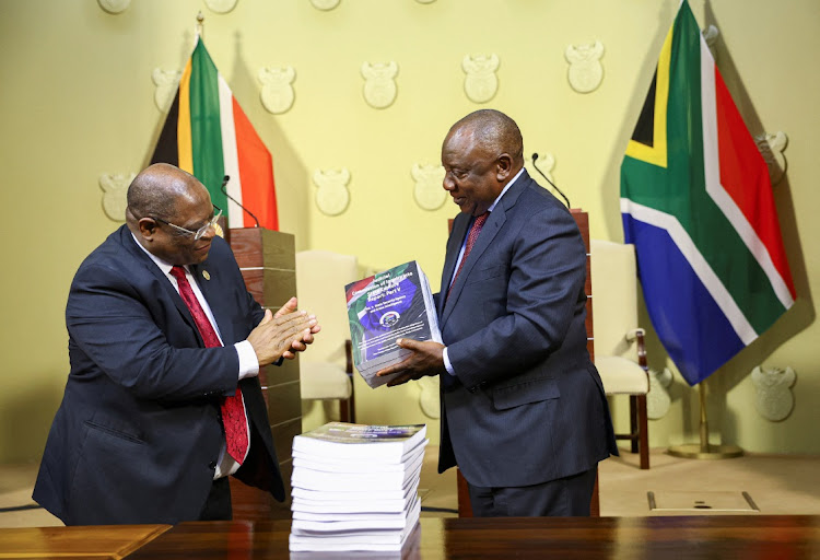 President Cyril Ramaphosa receives the final investigation report from chief justice Raymond Zondo at the Union Buildings in Pretoria on June 22 2022.