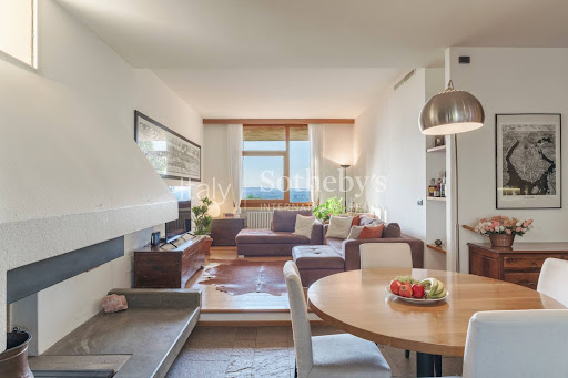 Modern living room with fireplace and dining area in this luxury property for sale in Verona ($3,363,021 - 800 m²)