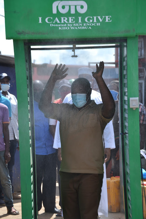 Kitui Senator Enoch Wambua sanitises at a public booth on Sunday