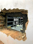 The hole hacked in the wall  to get into the vault where a  stash of expensive watches was kept.