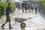 Residents in Taradale clean up silt following flood waters on February 15, 2023 in Napier, New Zealand. Cyclone Gabrielle has caused widespread destruction across New Zealand's North Island with thousands displaced and at least three reported deaths.