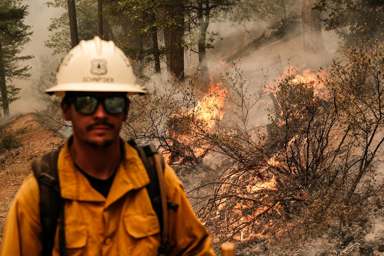 A firefighter monitors a control burn to prevent the fire line from reaching structures on North Arm Road during the Dixie Fire near Taylorsville, California, US, on August 15 2021. Picture: BLOOMBERG/DAVID ODISHO