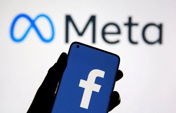 A smartphone with Facebook's logo is seen in front of displayed Facebook's new rebrand logo Meta in this illustration taken October 28, 2021.