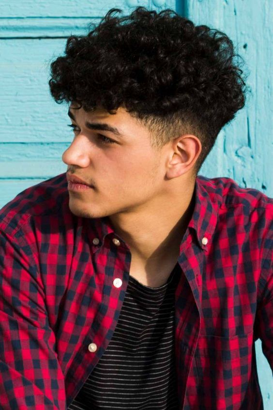 a young man rocking curly men's hairstyle