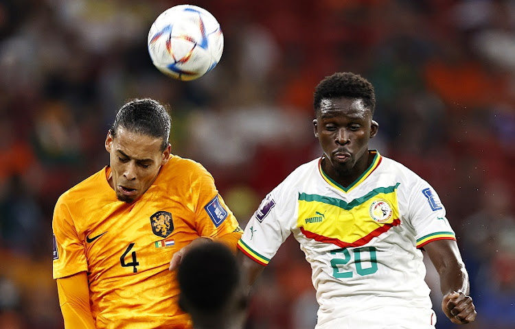 Virgil van Dijk of Holland competes in an aerial challenge with Ahmadou Bamba Dieng of Senegal in the World Cup Group A match at Al Thumama Stadium on November 21.