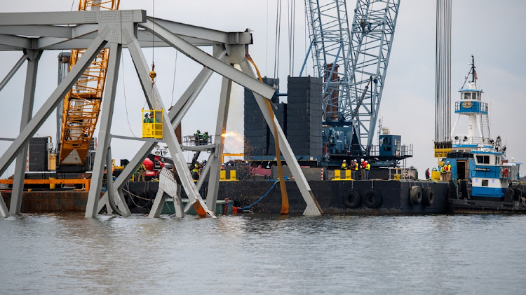 Demolition crews cut the top portion of the north side of the collapsed Francis Scott Key bridge into smaller sections for safe removal by crane in the Patapsco River, in Baltimore, Maryland, US, on March 30, 2024. Picture: US COAST GUARD/KIMBERLY REAVES/HANDOUT via REUTERS