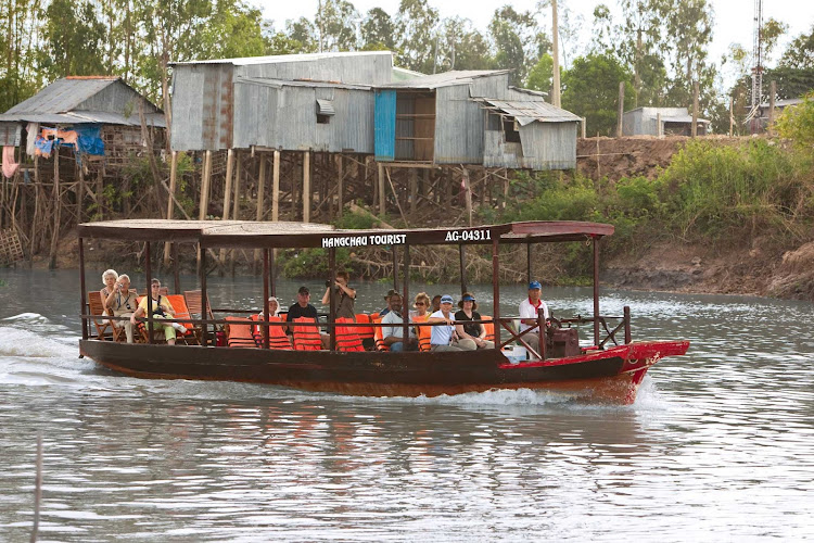 A tourism boat plies a tributary of the Mekong Delta in Châu Đốc, Vietnam, along the border with Cambodia.