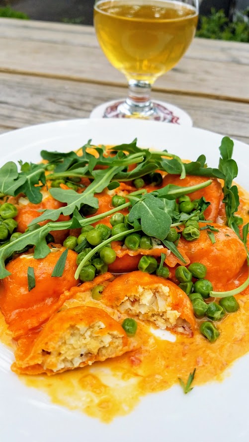 Of Roots and Blooms pops up every Wednesday at Bottles on Fremont and Sundays at Culmination Brewing offering rotating vegan delights. This Of Roots and Blooms vegan food example is their Vegan Lobster Ravioli with vegan lobster meat, chives and almond ricotta stuffed into red bell pepper pasta with tomato saffron cream sauce with Calabrian chilies and almond ricotta topped with arugula and peas