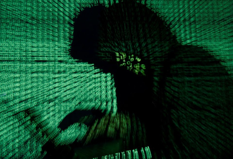 A man holds a laptop computer as cyber code is projected on him in this illustration picture taken on May 13, 2017.