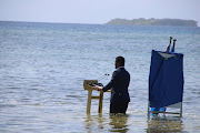 Tuvalu minister Simon Kofe gives a COP26 statement while standing in the ocean in Funafuti. 