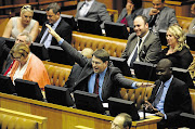 DA MP David Maynier adds a comical touch to proceedings during the National Assembly sitting as he gestures at Human Settlements Minister Lindiwe Sisulu yesterday.