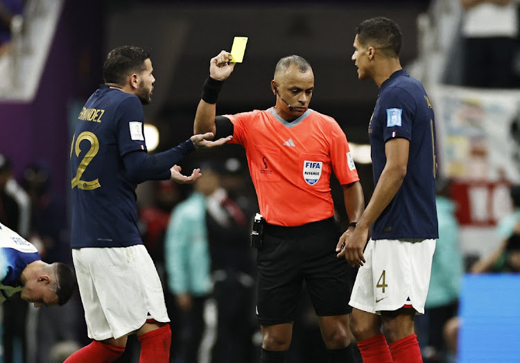 France's Theo Hernandez is shown a yellow card by referee Wilton Sampaio.