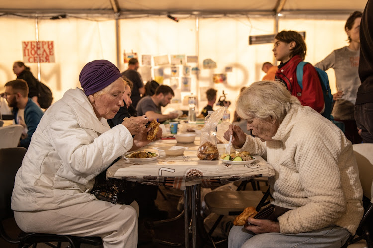 People eat in a reception tent after arriving from the Azovstal steel plant in Mariupol, in Zaporizhzhia,Ukraine. Picture: GETTY IMAGES/CHRIS MCGRATH