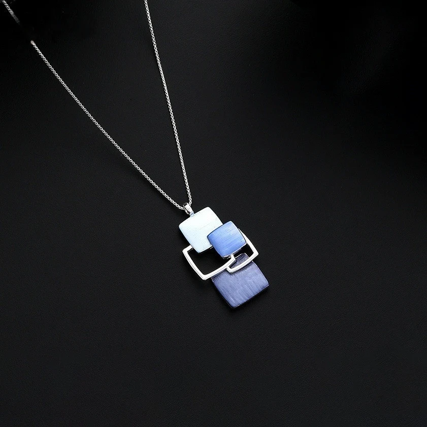 Pendentif bleu creux irrégulier fait à la main avec goutte à goutte d'huile créative. Un bijou unique pour un look original et artistique.