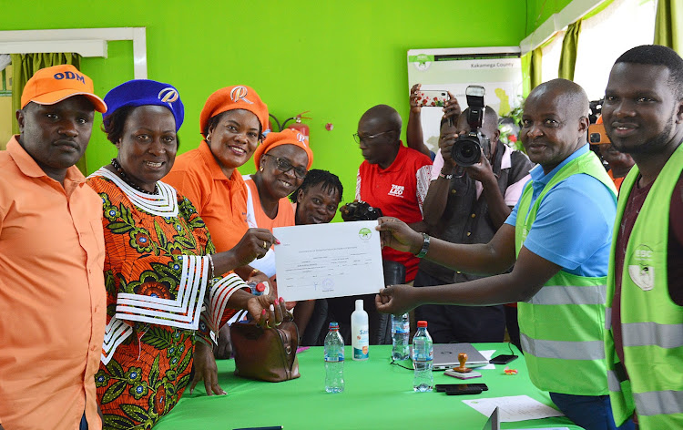 Kakamega Women Rep Elsie Muhanda receives her nomination certificate from Kakamega County IEBC Returning officer Joseph Ayatta.