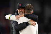 Liverpool manager Juergen Klopp embraces Jordan Henderson of Liverpool, who is wearing a captain's armband featuring the colours of Ukraine, after their Premier League match against Crystal Palace at Selhurst Park in London on February 25 2023.