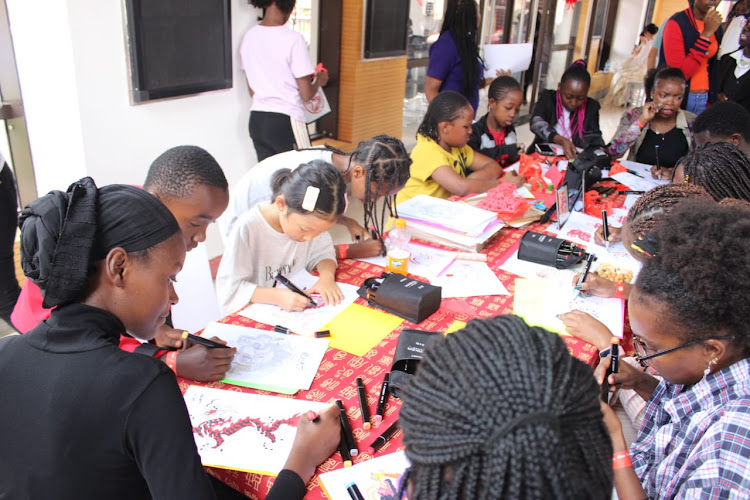 School children at a coloring session during 'The Dragon is soaring and the drums are rolling for the Chinese New Year' event at the Confucius Institute at the University of Nairobi on February 7, 2024