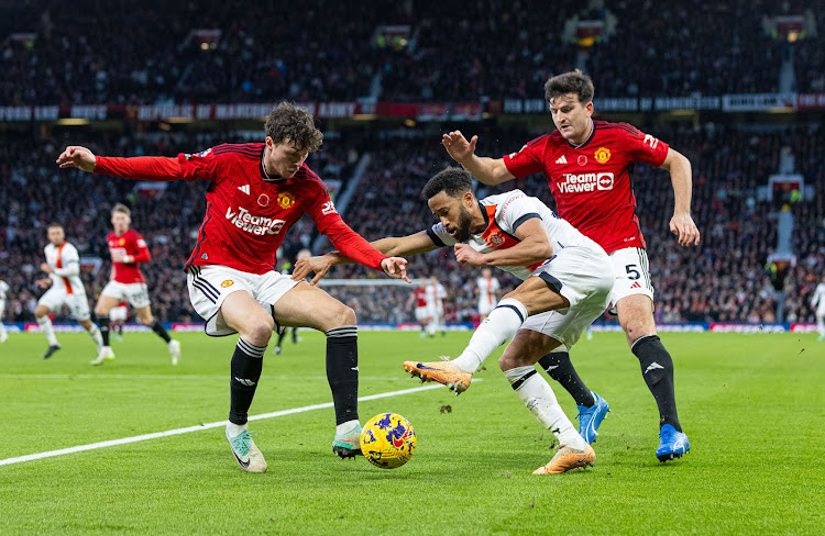 Luton Town's Andros Townsend (C) is challenged by Manchester United's Victor Lindelof (L) and Harry Maguire