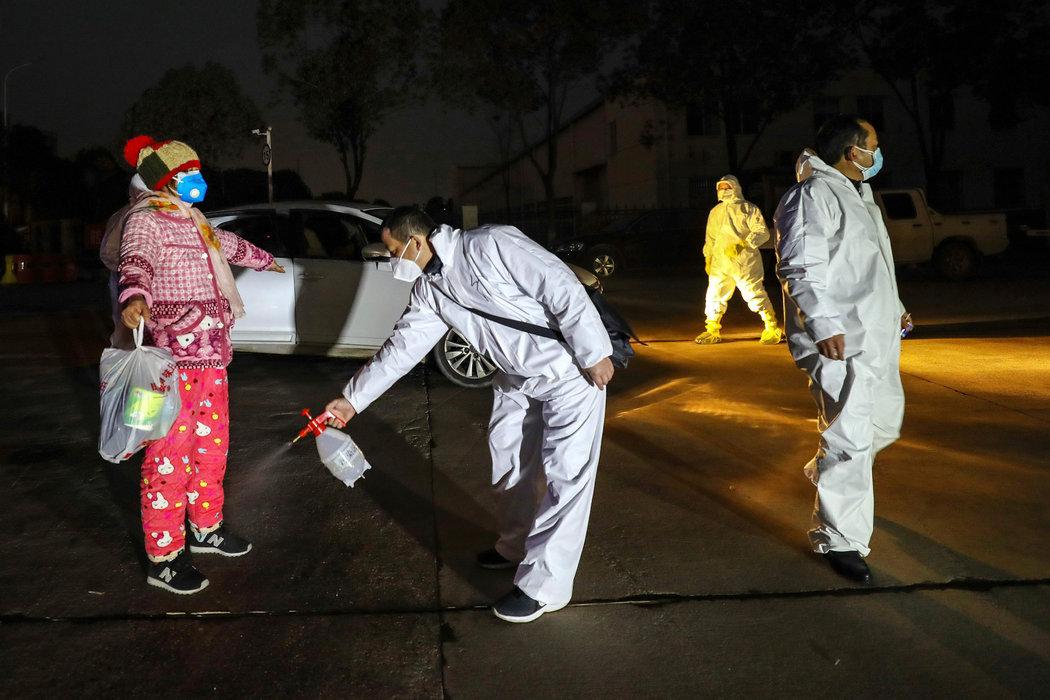 上周，医护人员为入住武汉一家隔离设施的人进行消毒。