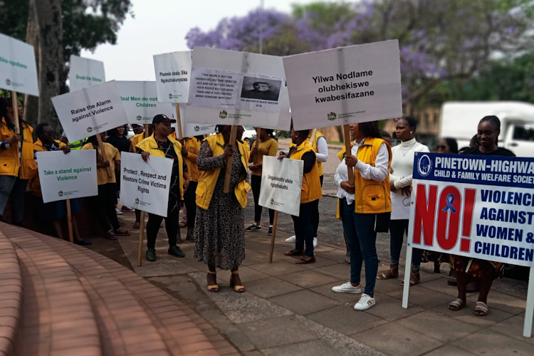 Social workers protest outside the Pinetown magistrate's court where a policeman accused of murdering two women is set to appear.