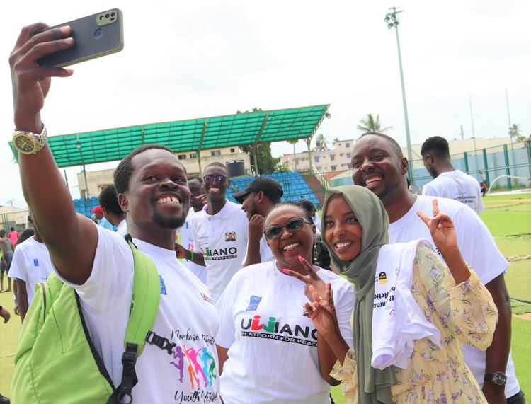 Mary Ndulili, the Inter-Religious Council of Kenya (IRCK) communication officer (centre) poses for a photo with youth from Changamwe, Mombasa on Saturday.