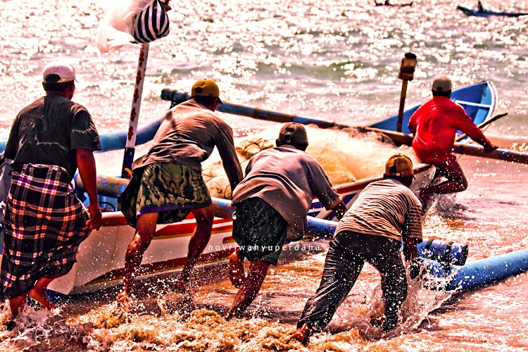 The photographer: "The spirit of Mutual Cooperation, or in Indonesia we called it Gotong Royong, is seen in this image. Together these Balinese fisherman helping each other everytime one of them is go fishing by pushing the boat from land to the sea."