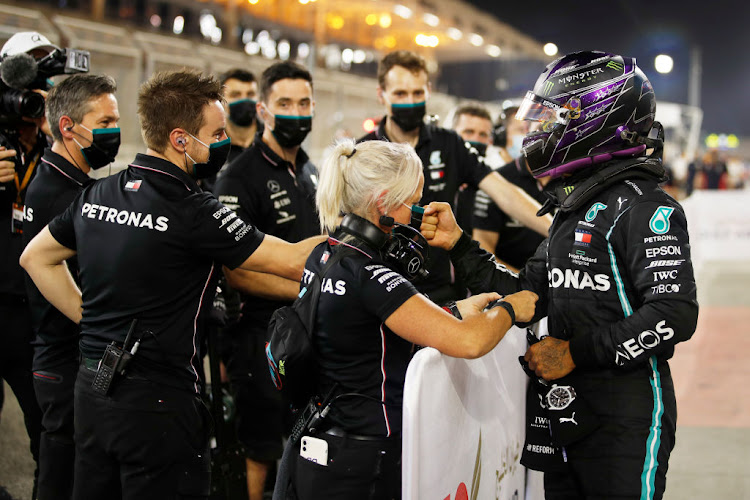 Pole position qualifier Lewis Hamilton of Great Britain and Mercedes GP celebrates with team members in parc ferme during qualifying ahead of the F1 Grand Prix of Bahrain at Bahrain International Circuit on November 28, 2020 in Bahrain, Bahrain.