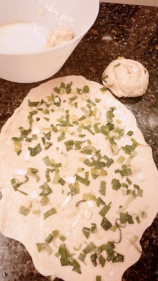 Recipe for Green Onion Pancake, also known as Scallion Pancakes - Flatten each of the balls, brush with sesame oil and sprink with scallions