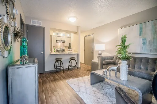 Furnished open concept living room and kitchen with wood plank floors and a neutral color scheme