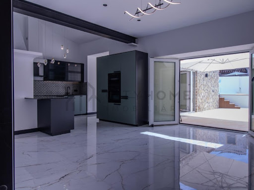 Modern kitchen with island and terrace access in this luxury house for sale in Pêra ($1,584,841)