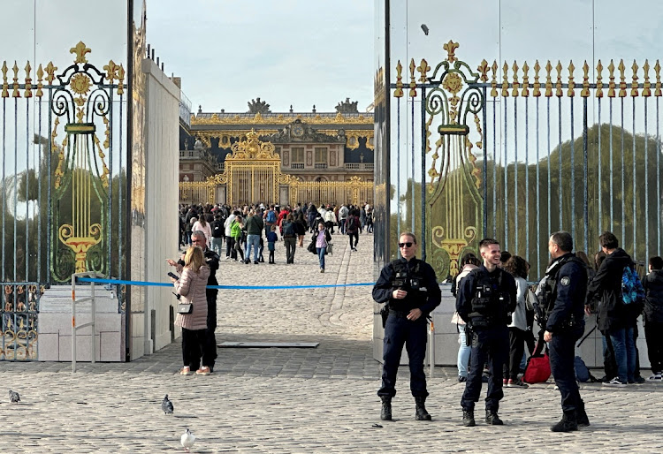 French police stand guard in front of the Chateau de Versailles (Palace of Versailles) as tourists enter again after the Palace was evacuated for security reasons