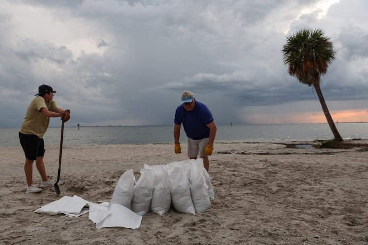 Rich Reynolds and his son John,18, fill sandbags, as Hurricane Ian spun toward the state carrying high winds, torrential rains and a powerful storm surge, at Ben T. Davis Beach in Tampa, Florida, US on September 26, 2022.