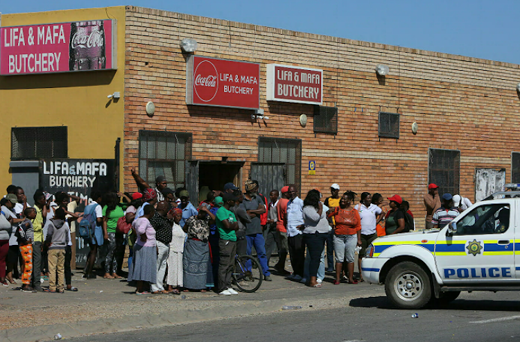 Crowds gather at the Lifa and Mafa Butchery where Baba Ningi was shot several times on January 28.