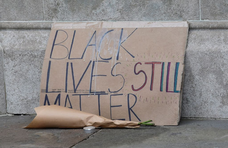 A placard is placed near the sculpture of a Black Lives Matter protester standing on the empty plinth previously occupied by the statue of slave trader Edward Colston, in Bristol, Britain, on July 15 2020.