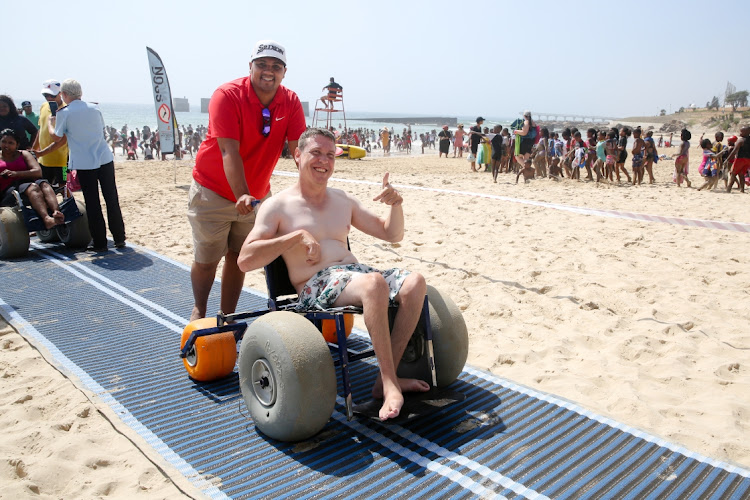 OCEAN DIP: Jannie Fick from Cheshire Homes, assisted by Cameron Lindoor, enjoyed a swim in the sea at Humewood Beach yesterday thanks to a new mat which provided the necessary access