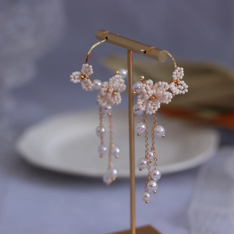 Boucles d'oreilles femme, fleurs de perles de riz et pompons, un accessoire élégant et raffiné. Idéales pour sublimer toutes vos tenues.