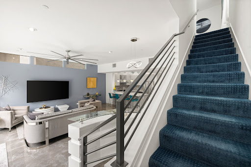 Modern living room with blue staircase in this luxury house for rent in Palm Springs ($5,500)