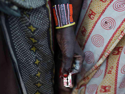 A Pokot woman holds a razor blade after performing circumcision on four girls in a village about 80 kilometres from the town of Marigat in Baringo county, October 16, 2014. /REUTERS