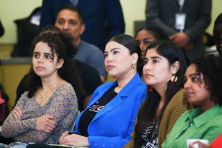 Four women sitting and listening to someone.