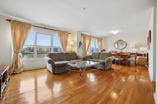 Living room with water and exterior view in this luxury apartment / penthouse for sale in Edgewater ($609,000)